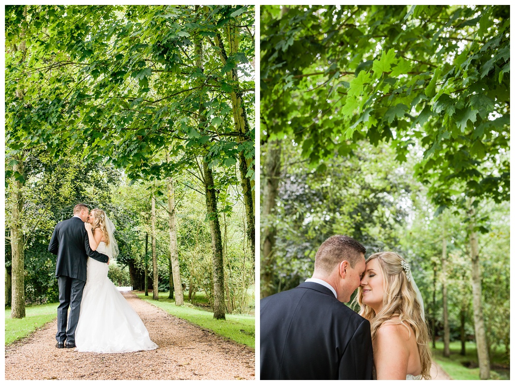 Bride and groom on tree lined path at Broyle Place