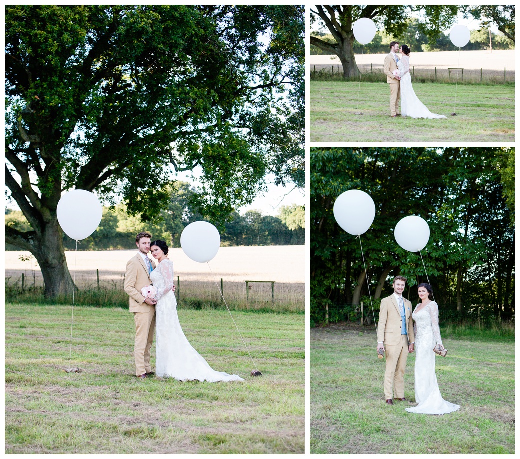 bride and groom with big white balloons