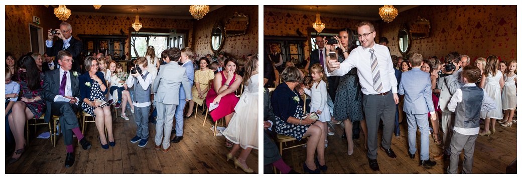 wedding guests photograph bride and groom during the signing of the register