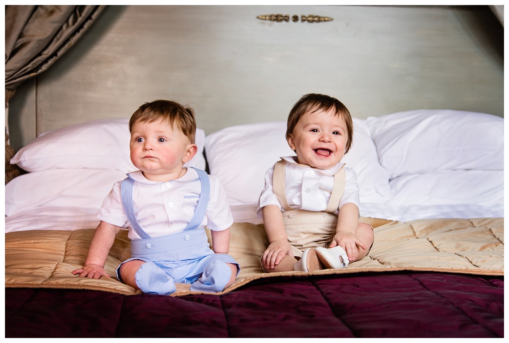 twin baby boys sat on bed
